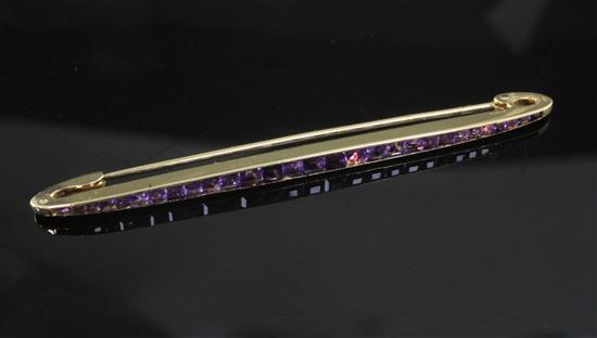A Cartier amethyst and 18ct gold bar brooch, channel-set with 29 square-cut rubies, signed Cartier, Paris numbered 3056?,